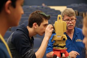 A student works with a total station during the civil engineering lesson at Camp STEM